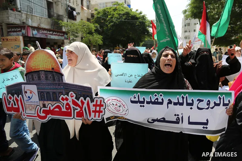 Palestinian protesters shout slogans and hold placards during a demonstration against Israeli security measures that were implemented at the Al-Aqsa mosque compound in Jerusalem the previous week prior to being removed a...