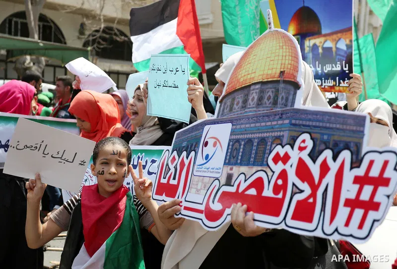 Palestinian protesters shout slogans and hold placards during a demonstration against Israeli security measures that were implemented at the Al-Aqsa mosque compound in Jerusalem the previous week prior to being removed a...