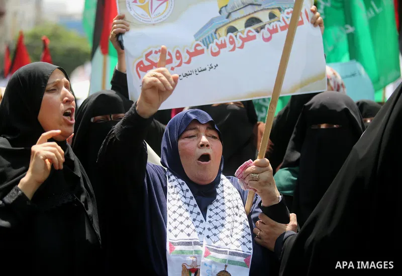Palestinian protesters shout slogans and hold placards during a demonstration against Israeli security measures that were implemented at the Al-Aqsa mosque compound in Jerusalem the previous week prior to being removed a...