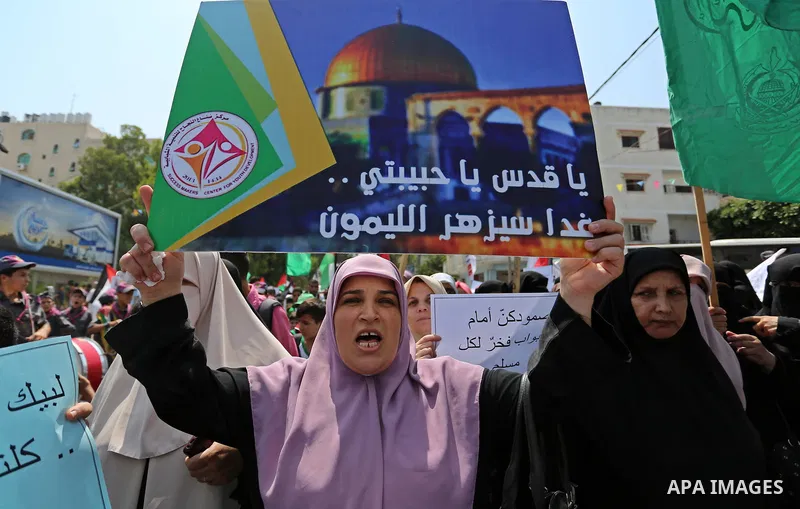 Palestinian protesters shout slogans and hold placards during a demonstration against Israeli security measures that were implemented at the Al-Aqsa mosque compound in Jerusalem the previous week prior to being removed a...