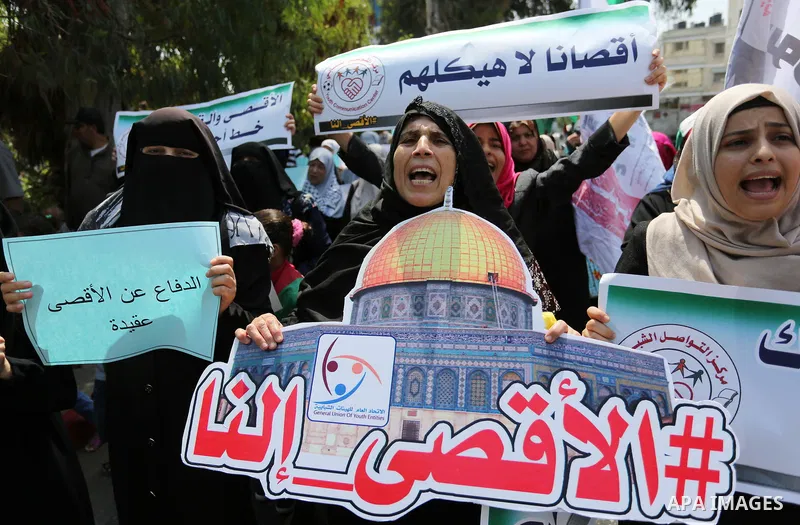 Palestinian protesters shout slogans and hold placards during a demonstration against Israeli security measures that were implemented at the Al-Aqsa mosque compound in Jerusalem the previous week prior to being removed a...
