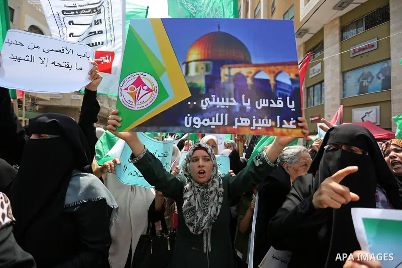 Palestinian protesters shout slogans and hold placards during a demonstration against Israeli security measures that were implemented at the Al-Aqsa mosque compound in Jerusalem the previous week prior to being removed a...