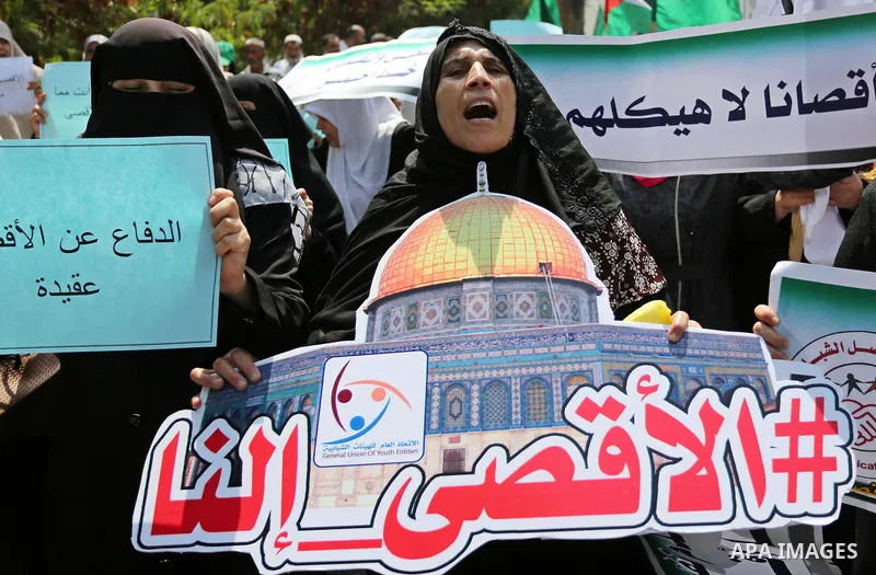 Palestinian protesters shout slogans and hold placards during a demonstration against Israeli security measures that were implemented at the Al-Aqsa mosque compound in Jerusalem the previous week prior to being removed a...