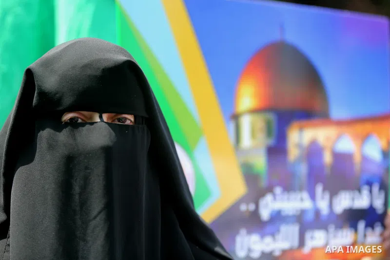 A masked female protester takes part during a demonstration against Israeli security measures that were implemented at the Al-Aqsa mosque compound in Jerusalem the previous week prior to being removed after their install...