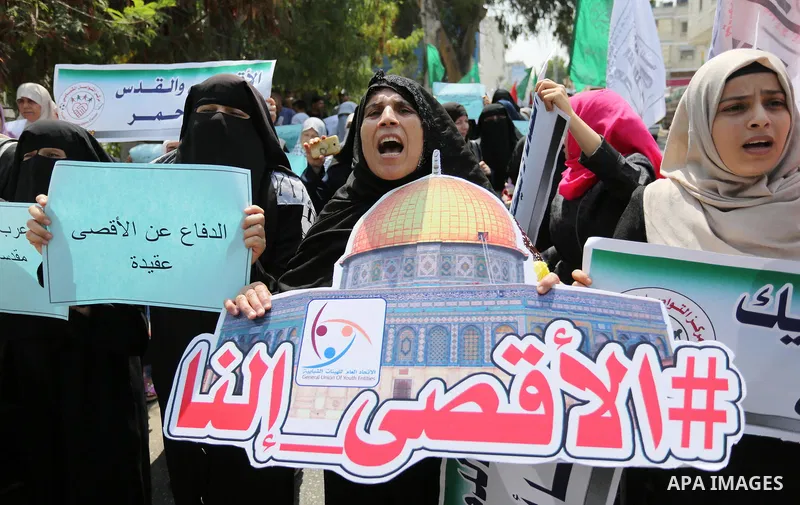 Palestinian protesters shout slogans and hold placards during a demonstration against Israeli security measures that were implemented at the Al-Aqsa mosque compound in Jerusalem the previous week prior to being removed a...
