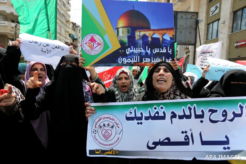 Palestinian protesters shout slogans and hold placards during a demonstration against Israeli security measures that were implemented at the Al-Aqsa mosque compound in Jerusalem the previous week prior to being removed a...