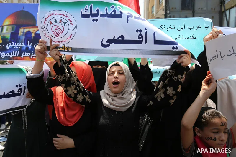 Palestinian protesters shout slogans and hold placards during a demonstration against Israeli security measures that were implemented at the Al-Aqsa mosque compound in Jerusalem the previous week prior to being removed a...