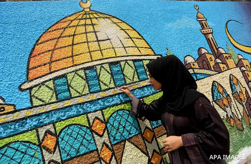 A Palestinian artist paints a mural drawing depicting the Dome of the Rock Mosque against Israeli security measures that were implemented at the Al-Aqsa mosque compound in Jerusalem the previous week prior to being remov...
