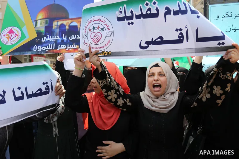 Palestinian protesters shout slogans and hold placards during a demonstration against Israeli security measures that were implemented at the Al-Aqsa mosque compound in Jerusalem the previous week prior to being removed a...