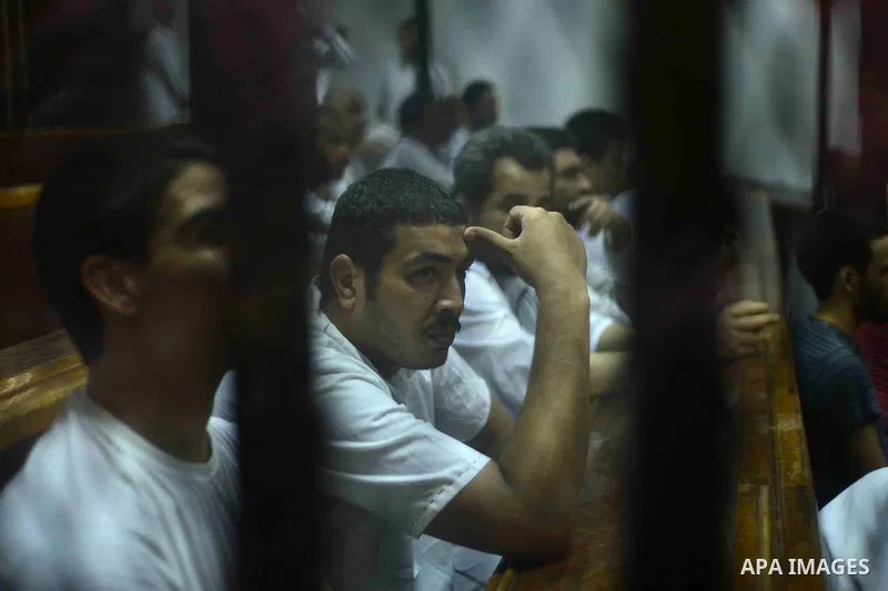 Egyptian defendants sits behind the defendant's bars during their trial at "Cabinet Incidents" case at the court in Cairo, Egypt, on July 25, 2017. An Egyptian criminal court sentenced 43 activists to life in prison on T...