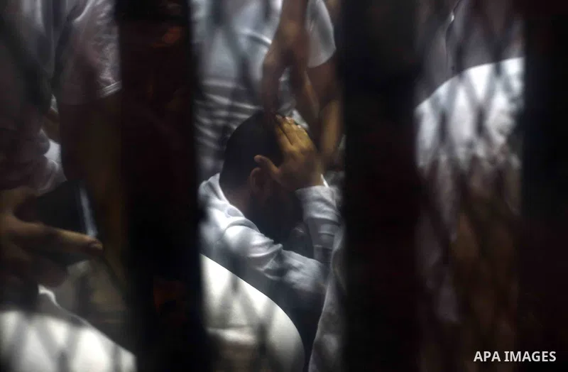 Egyptian defendants sits behind the defendant's bars during their trial at "Cabinet Incidents" case at the court in Cairo, Egypt, on July 25, 2017. An Egyptian criminal court sentenced 43 activists to life in prison on T...