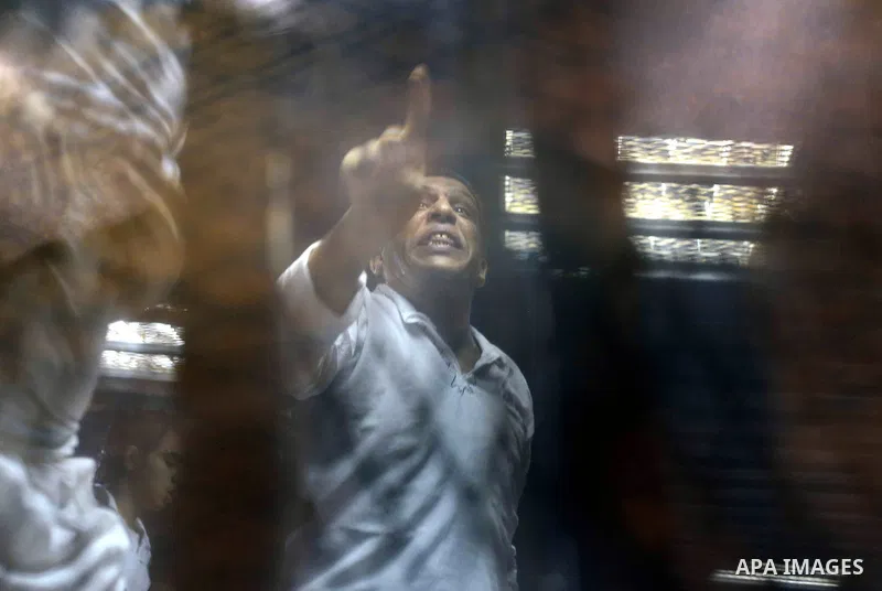 Egyptian defendants sits behind the defendant's bars during their trial at "Cabinet Incidents" case at the court in Cairo, Egypt, on July 25, 2017. An Egyptian criminal court sentenced 43 activists to life in prison on T...