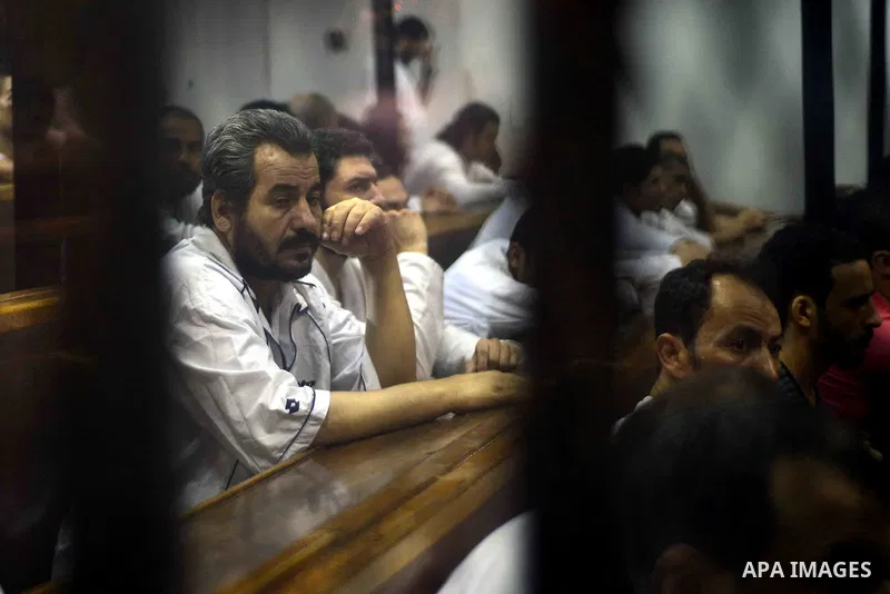 Egyptian defendants sits behind the defendant's bars during their trial at "Cabinet Incidents" case at the court in Cairo, Egypt, on July 25, 2017. An Egyptian criminal court sentenced 43 activists to life in prison on T...