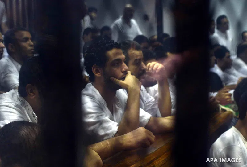 Egyptian defendants sits behind the defendant's bars during their trial at "Cabinet Incidents" case at the court in Cairo, Egypt, on July 25, 2017. An Egyptian criminal court sentenced 43 activists to life in prison on T...
