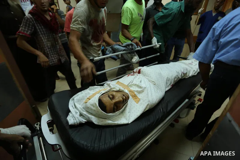 Relatives of a 16-year-old Palestinian, who was reportedly killed in clashes with the Israeli army along the Gaza border, view his body at a hospital in Deir al-Balah in the central Gaza strip on July 28, 2017. Photo by...