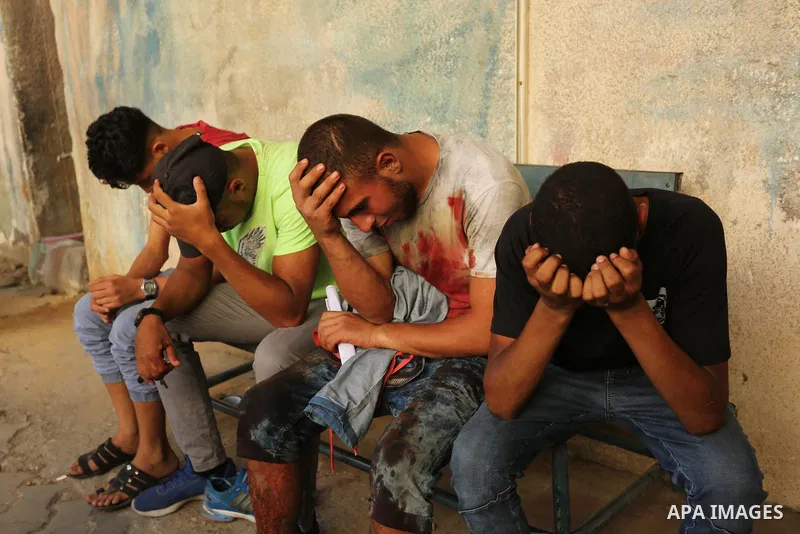 Relatives of a 16-year-old Palestinian, who was reportedly killed in clashes with the Israeli army along the Gaza border, mourn at a hospital in Deir al-Balah in the central Gaza Strip on July 28, 2017. Photo by Ashraf A...
