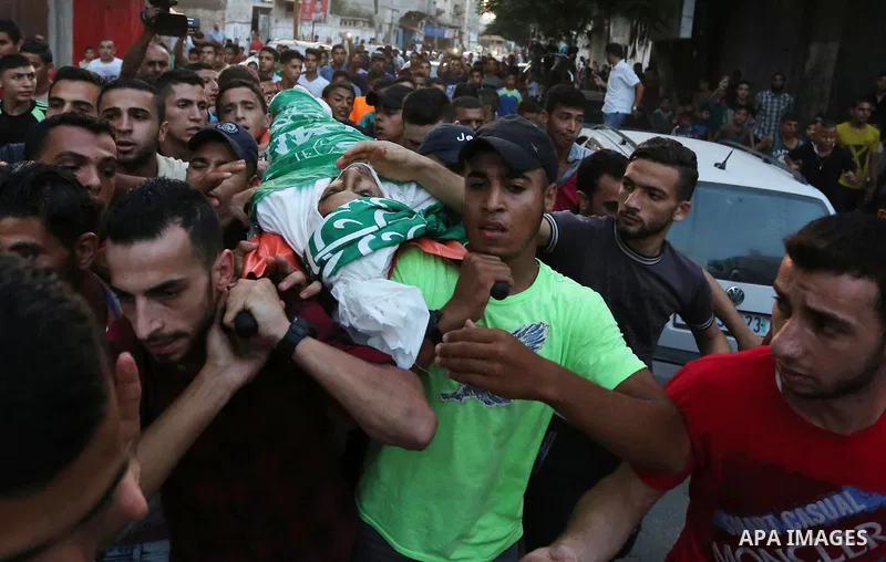 Palestinianmen carry the body of 16 year old Abed Hussian Abu Hasimeh, who was shot dead by Israeli forces during clashes, as they march in his funeral in the Bureij refugee camp in central Gaza on July 28, 2017. Israeli...