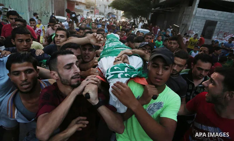 Palestinianmen carry the body of 16 year old Abed Hussian Abu Hasimeh, who was shot dead by Israeli forces during clashes, as they march in his funeral in the Bureij refugee camp in central Gaza on July 28, 2017. Israeli...