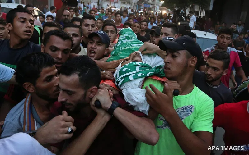 Palestinianmen carry the body of 16 year old Abed Hussian Abu Hasimeh, who was shot dead by Israeli forces during clashes, as they march in his funeral in the Bureij refugee camp in central Gaza on July 28, 2017. Israeli...