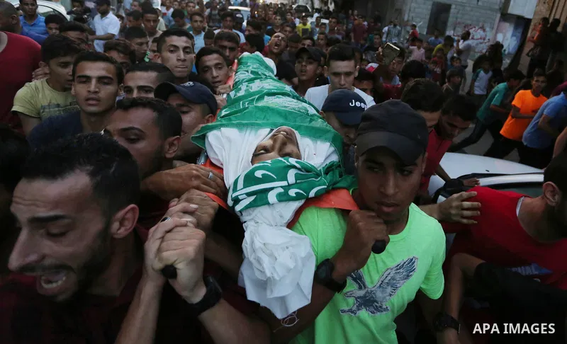 Palestinianmen carry the body of 16 year old Abed Hussian Abu Hasimeh, who was shot dead by Israeli forces during clashes, as they march in his funeral in the Bureij refugee camp in central Gaza on July 28, 2017. Israeli...