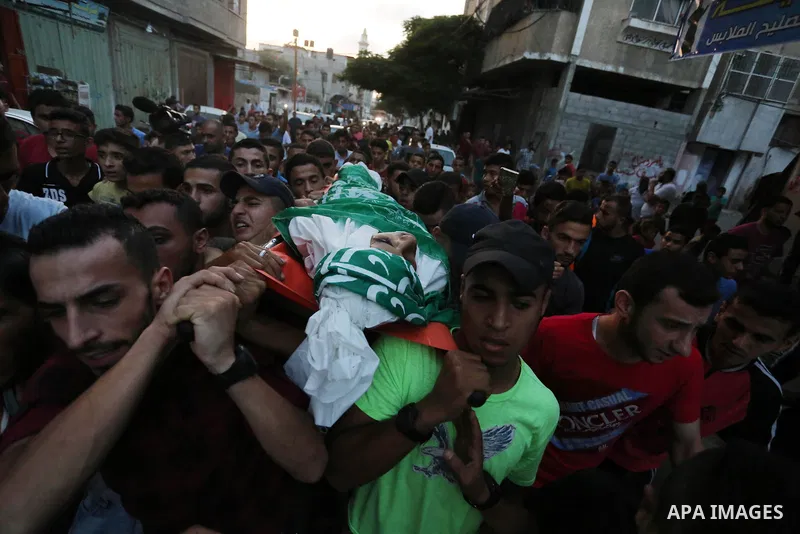 Palestinianmen carry the body of 16 year old Abed Hussian Abu Hasimeh, who was shot dead by Israeli forces during clashes, as they march in his funeral in the Bureij refugee camp in central Gaza on July 28, 2017. Israeli...