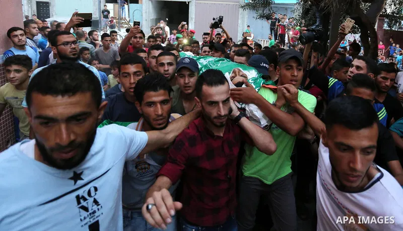 Palestinianmen carry the body of 16 year old Abed Hussian Abu Hasimeh, who was shot dead by Israeli forces during clashes, as they march in his funeral in the Bureij refugee camp in central Gaza on July 28, 2017. Israeli...