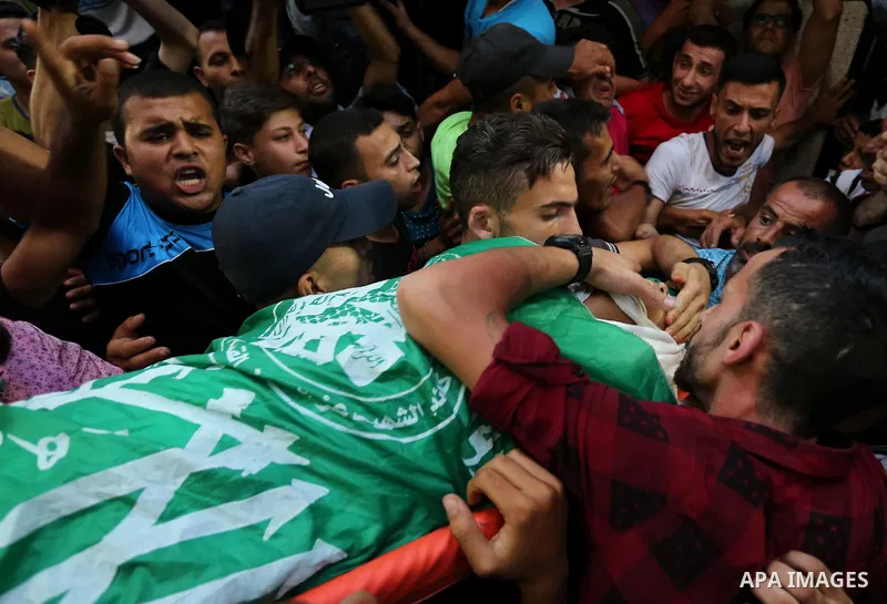 Palestinianmen carry the body of 16 year old Abed Hussian Abu Hasimeh, who was shot dead by Israeli forces during clashes, as they march in his funeral in the Bureij refugee camp in central Gaza on July 28, 2017. Israeli...