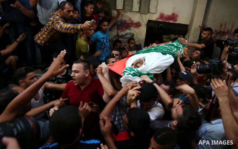 Palestinianmen carry the body of 16 year old Abed Hussian Abu Hasimeh, who was shot dead by Israeli forces during clashes, as they march in his funeral in the Bureij refugee camp in central Gaza on July 28, 2017. Israeli...