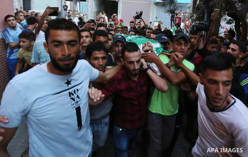 Palestinianmen carry the body of 16 year old Abed Hussian Abu Hasimeh, who was shot dead by Israeli forces during clashes, as they march in his funeral in the Bureij refugee camp in central Gaza on July 28, 2017. Israeli...