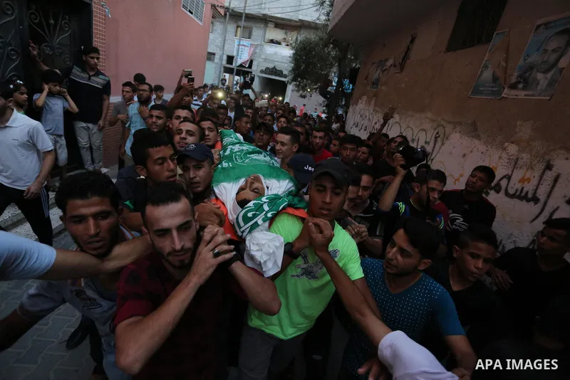 Palestinianmen carry the body of 16 year old Abed Hussian Abu Hasimeh, who was shot dead by Israeli forces during clashes, as they march in his funeral in the Bureij refugee camp in central Gaza on July 28, 2017. Israeli...