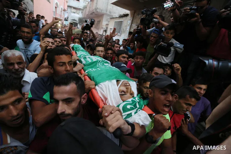 Palestinianmen carry the body of 16 year old Abed Hussian Abu Hasimeh, who was shot dead by Israeli forces during clashes, as they march in his funeral in the Bureij refugee camp in central Gaza on July 28, 2017. Israeli...