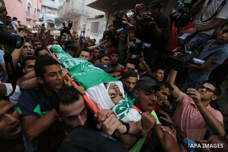 Palestinianmen carry the body of 16 year old Abed Hussian Abu Hasimeh, who was shot dead by Israeli forces during clashes, as they march in his funeral in the Bureij refugee camp in central Gaza on July 28, 2017. Israeli...