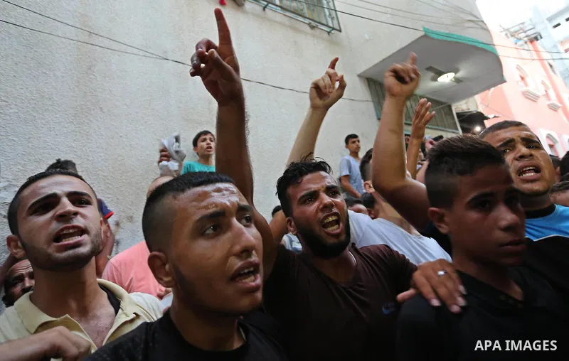 Palestinianmen carry the body of 16 year old Abed Hussian Abu Hasimeh, who was shot dead by Israeli forces during clashes, as they march in his funeral in the Bureij refugee camp in central Gaza on July 28, 2017. Israeli...