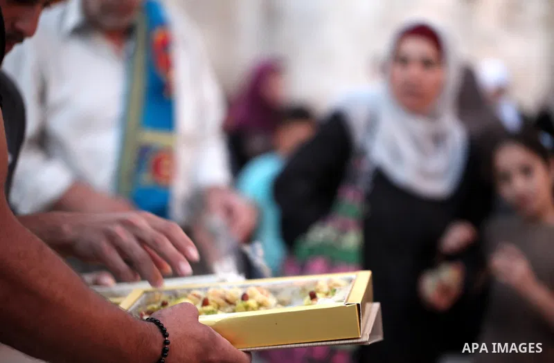 A Palestinian man distributes sweets to people as part of celebrations marking Israel's removal of all security measures it had installed at the compound known to Muslims as Noble Sanctuary and to Jews as Temple Mount, i...