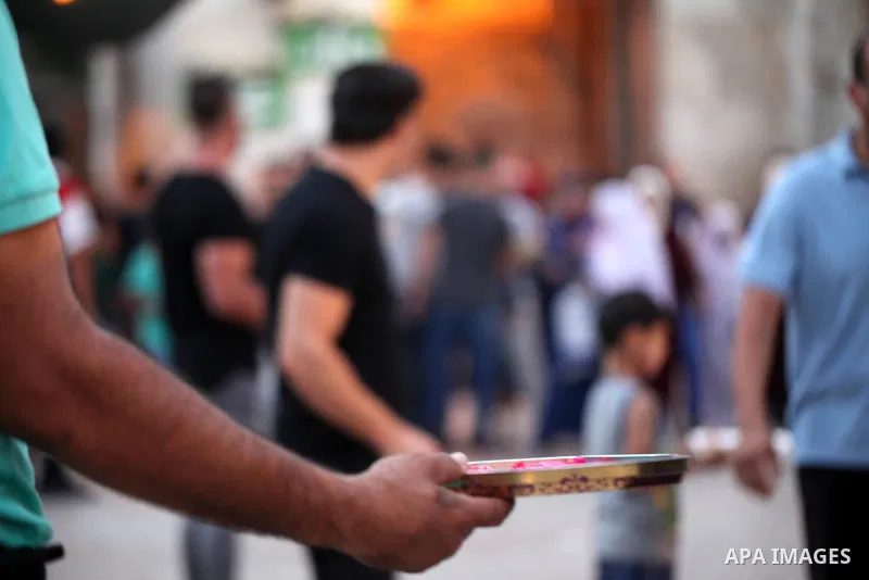 A Palestinian man distributes sweets to people as part of celebrations marking Israel's removal of all security measures it had installed at the compound known to Muslims as Noble Sanctuary and to Jews as Temple Mount, i...