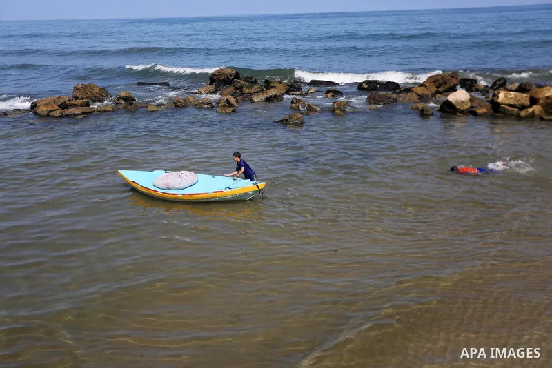 Palestinian boys swim at Gaza seaport in Gaza City on July 31, 2017. Photo by Mohammed Asad