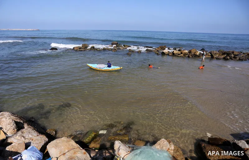 Palestinian boys swim at Gaza seaport in Gaza City on July 31, 2017. Photo by Mohammed Asad