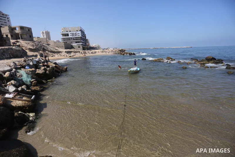 Palestinian boys swim at Gaza seaport in Gaza City on July 31, 2017. Photo by Mohammed Asad