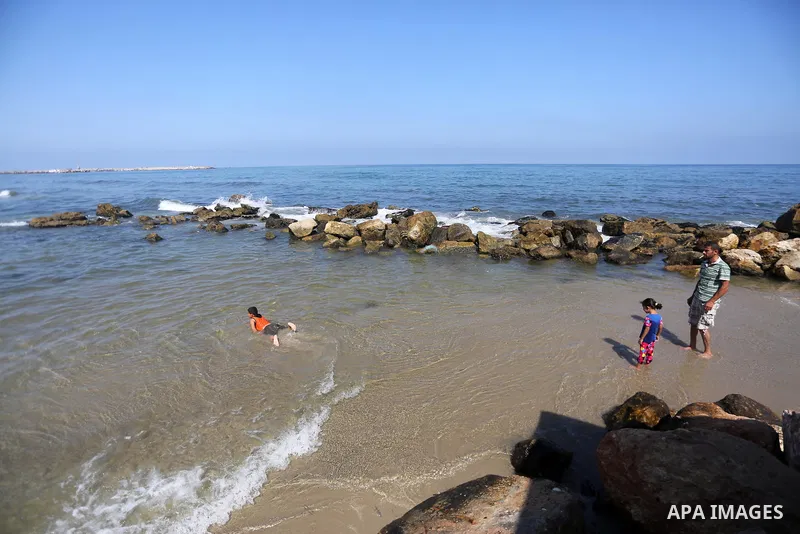 Palestinian boys swim at Gaza seaport in Gaza City on July 31, 2017. Photo by Mohammed Asad