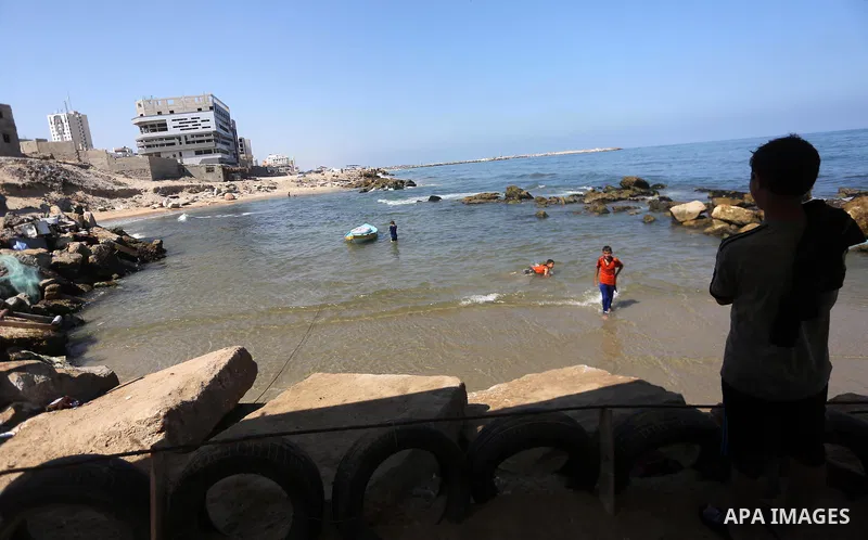 Palestinian boys swim at Gaza seaport in Gaza City on July 31, 2017. Photo by Mohammed Asad