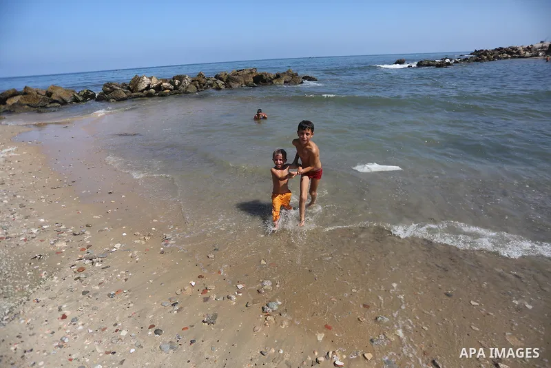 Palestinian boys swim at Gaza seaport in Gaza City on July 31, 2017. Photo by Mohammed Asad