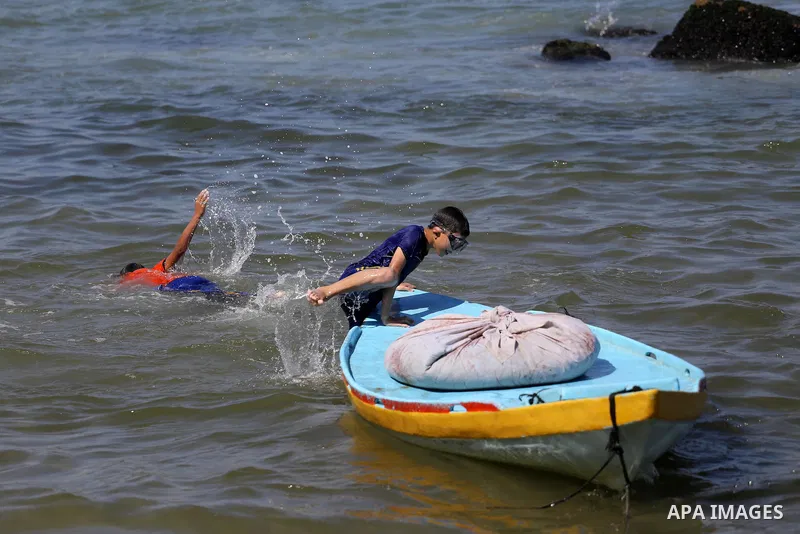 Palestinian boys swim at Gaza seaport in Gaza City on July 31, 2017. Photo by Mohammed Asad