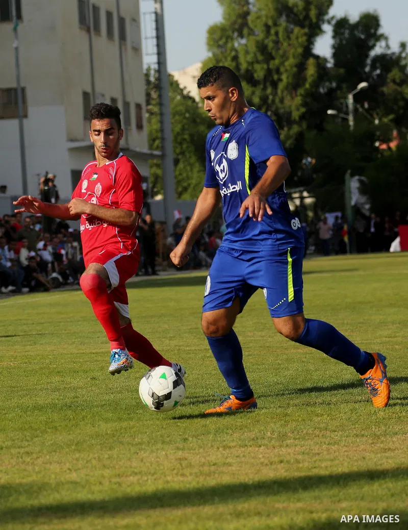 Players of Shabab Rafah football club compete with players of Hebron's Ahly al-Khalil football club in the first leg of the Palestine Cup final at the Yarmouk Stadium in Gaza City on August 1, 2017. Photo by Ashraf Amra