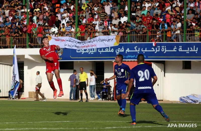 Players of Shabab Rafah football club compete with players of Hebron's Ahly al-Khalil football club in the first leg of the Palestine Cup final at the Yarmouk Stadium in Gaza City on August 1, 2017. Photo by Ashraf Amra