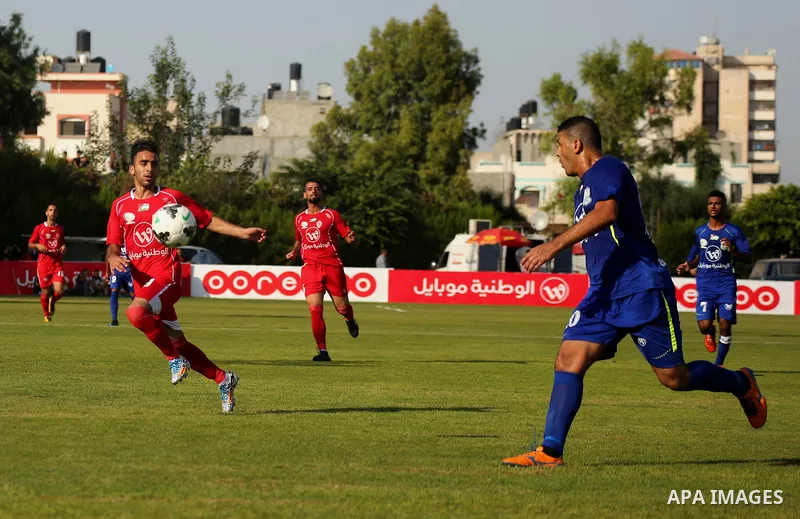 Players of Shabab Rafah football club compete with players of Hebron's Ahly al-Khalil football club in the first leg of the Palestine Cup final at the Yarmouk Stadium in Gaza City on August 1, 2017. Photo by Ashraf Amra