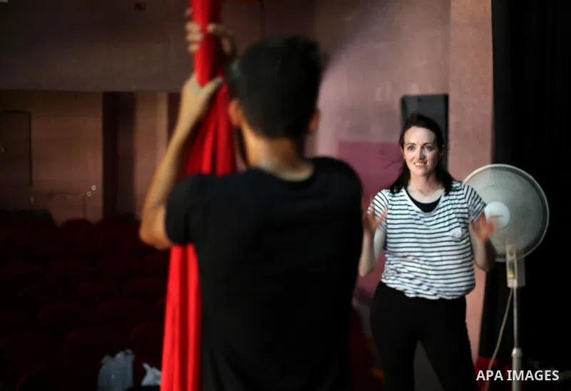 An Irish trainer, Jennifer Higgins, helps a member of Gaza circus to perform during an aerial silks practice class in Gaza City, on August 3, 2017. Photo by Mohammed Asad