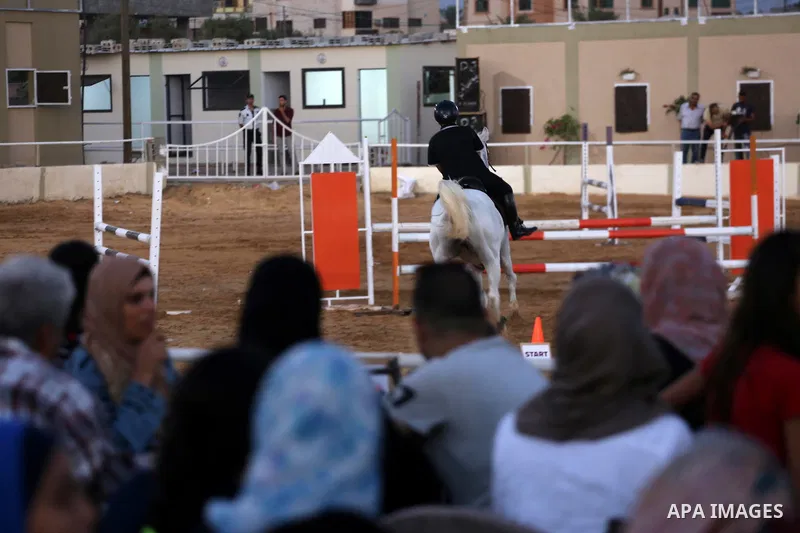 A Palestinian boy rides his horse during a jump obstacles championship, in Gaza city on August 4, 2017. Photo by Mohammed Asad