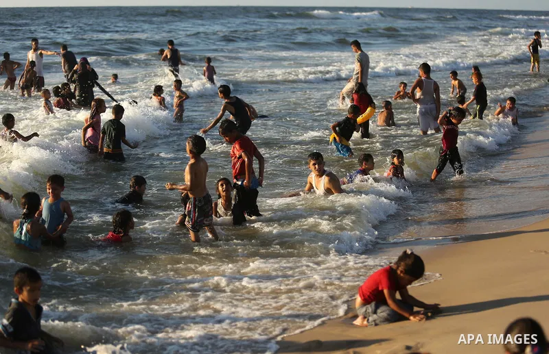 Palestinians enjoy their time at the beach of the Mediterranean sea on the coast of Gaza city on August 4, 2017. Photo by Ashraf Amra