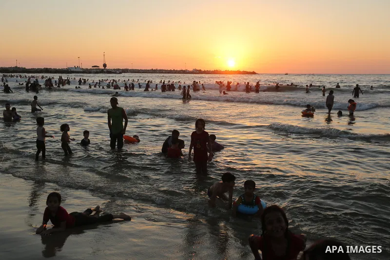 Palestinians enjoy their time at the beach of the Mediterranean sea on the coast of Gaza city on August 4, 2017. Photo by Ashraf Amra
