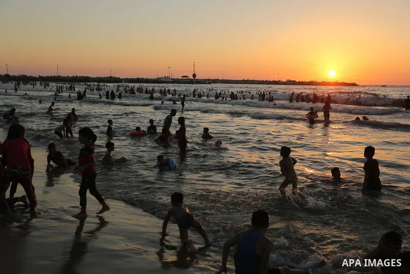 Palestinians enjoy their time at the beach of the Mediterranean sea on the coast of Gaza city on August 4, 2017. Photo by Ashraf Amra
